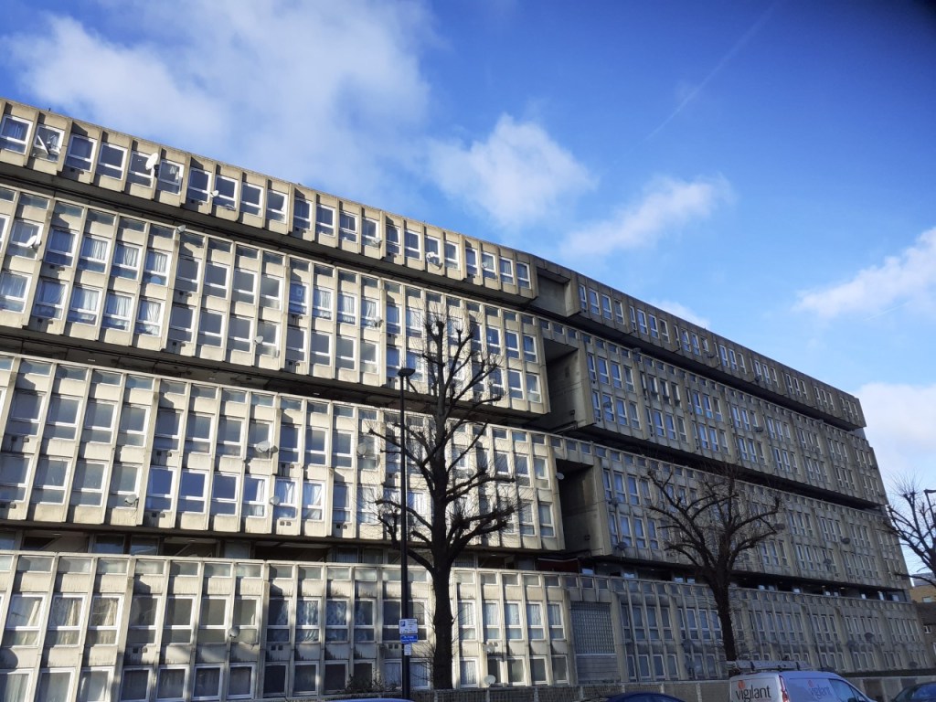 Building front of Robin Hood Gardens. A wide building containing many windows.
